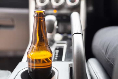 a beer bottle in a car cup holder